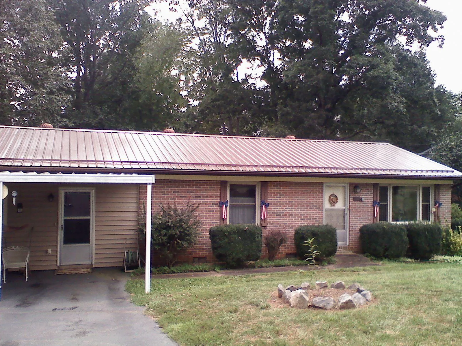 Bronze metal roof and carport on a brick ranch home — Roof Repair work by our crew in Norcross